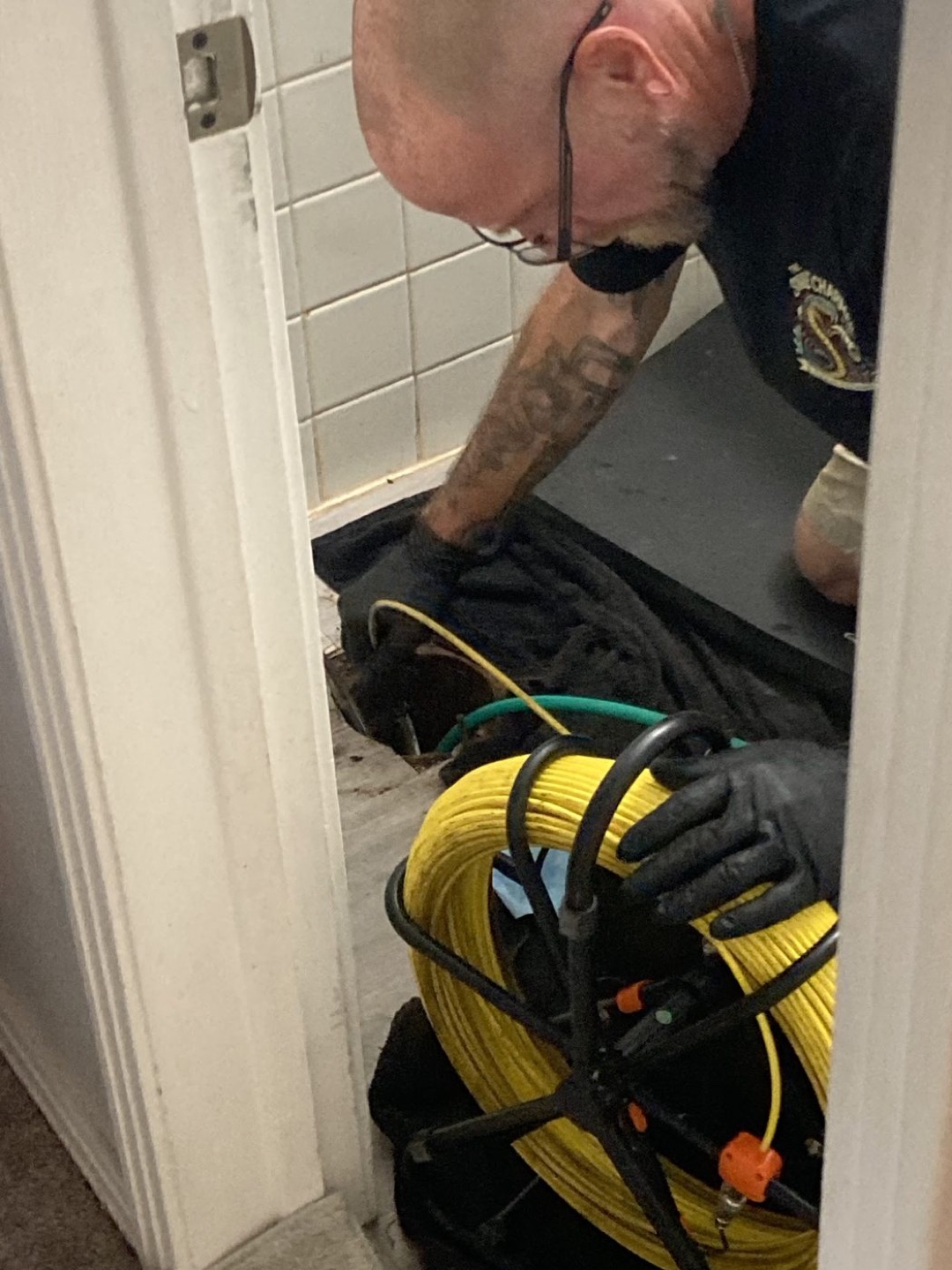 Drain technician feeding an inspection cable into a residential drain access